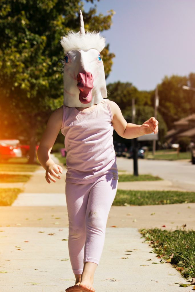 Photo by Andrea Tummons on Unsplash.
Person in Unicorn mask and dirty pink pajamas walking down the road.