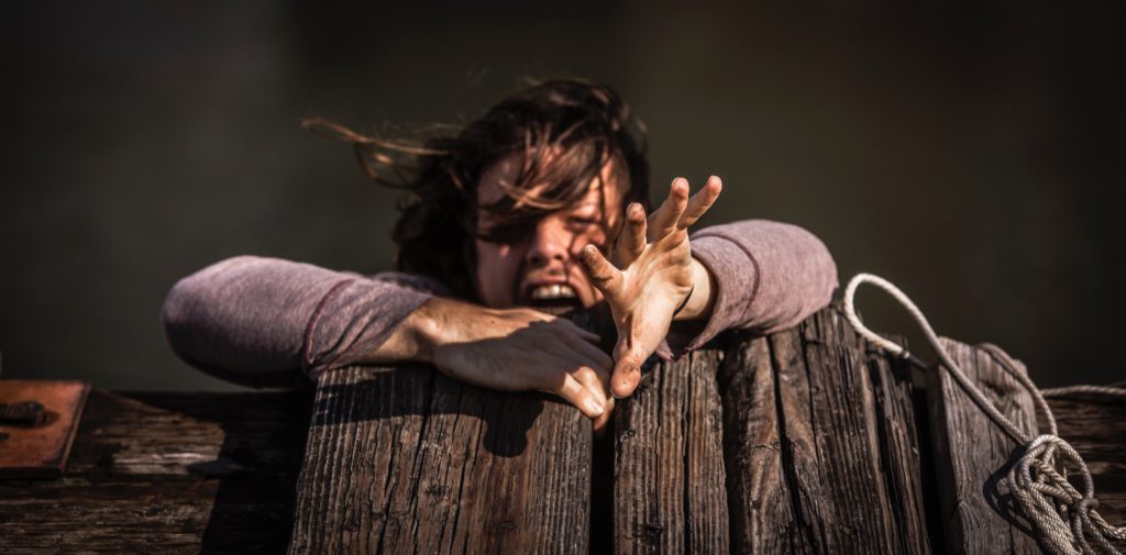 Photo by Pedro da Silva on Unsplash.
A man reaches out as he is falling (hand is in focus).